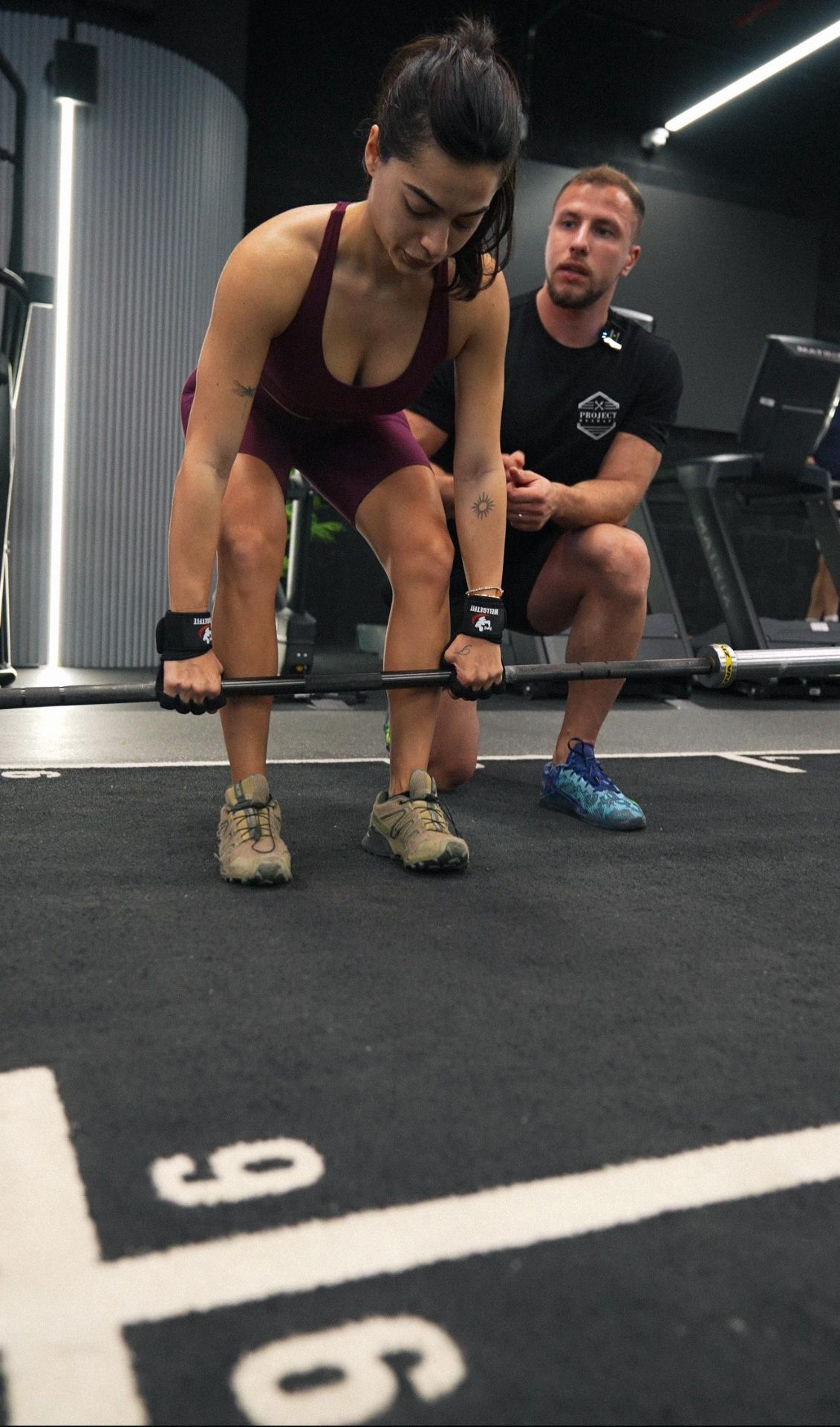 Project Reshape coach cueing a client through a barbell deadlift set-up
